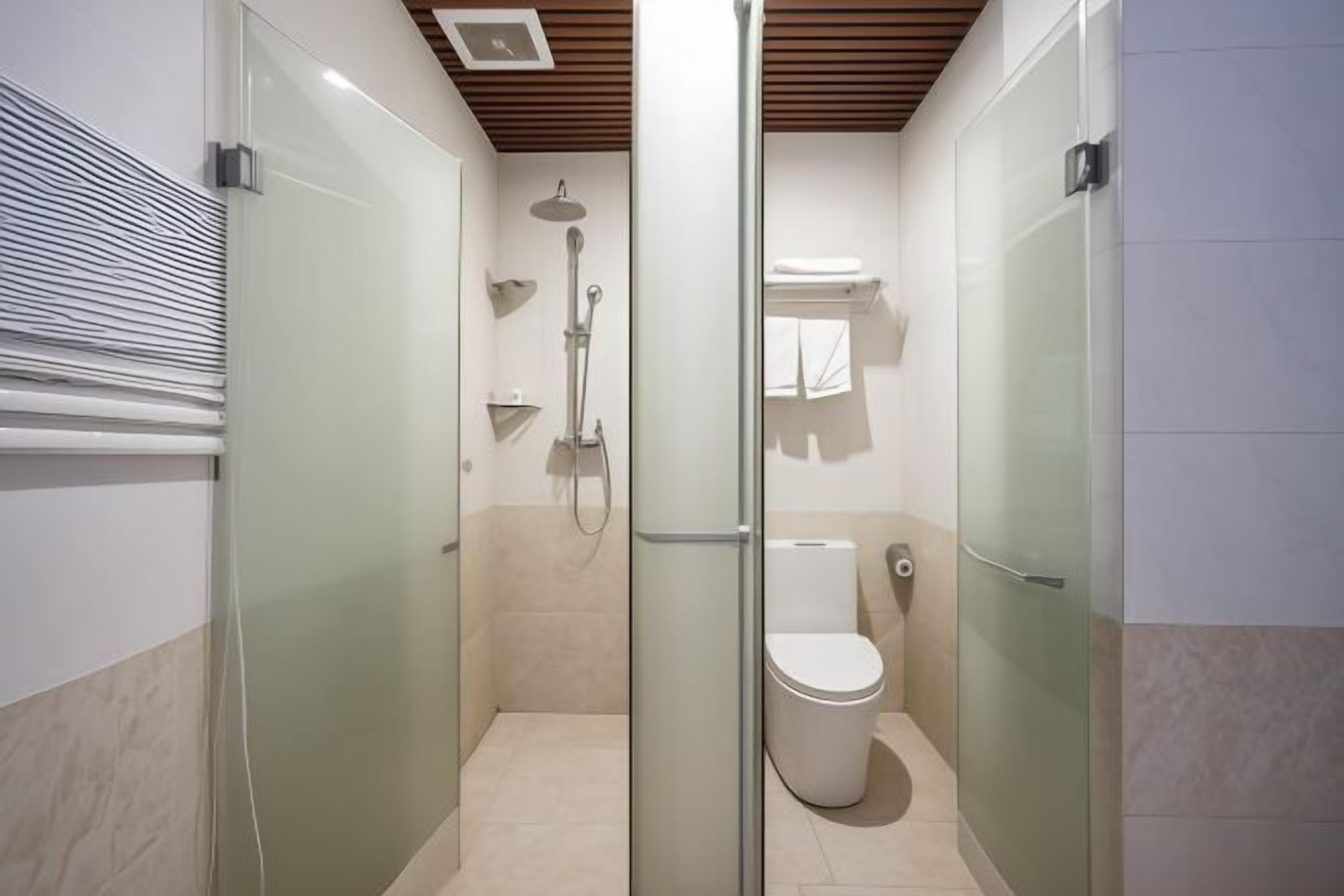 Un baño moderno con ducha de vidrio, inodoro y toallero.