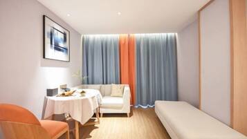 Una habitación moderna con una mesa redonda, un sofá y un banco.