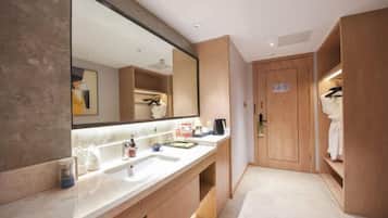 Un baño moderno con un espejo grande, dos lavamanos y armarios de madera.