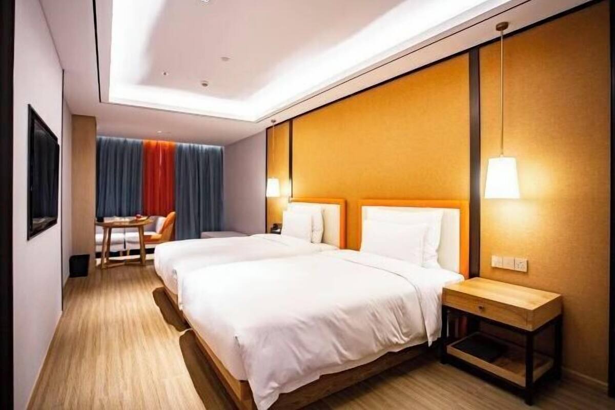 A hotel room with a large bed, bedside tables, a desk, and a chair.