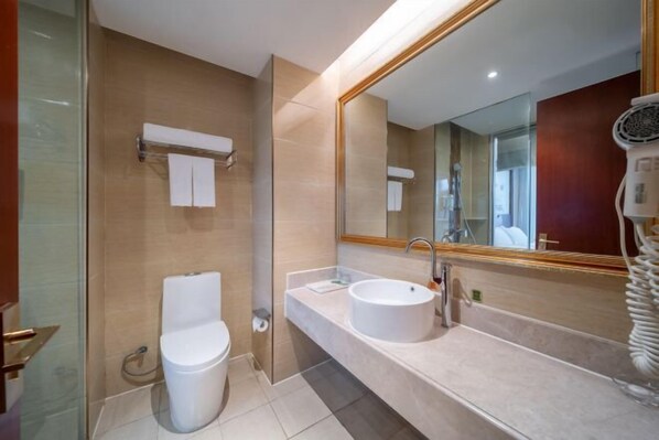 A modern bathroom with a glass shower enclosure, a white toilet, a double sink vanity, and a large mirror.