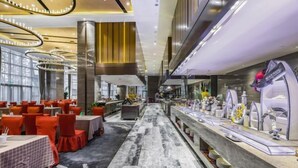 A modern restaurant with marble flooring, red chairs, and a central serving counter. - Shangqiu Xinhua Jianguo Hotel (Shangqiu)
