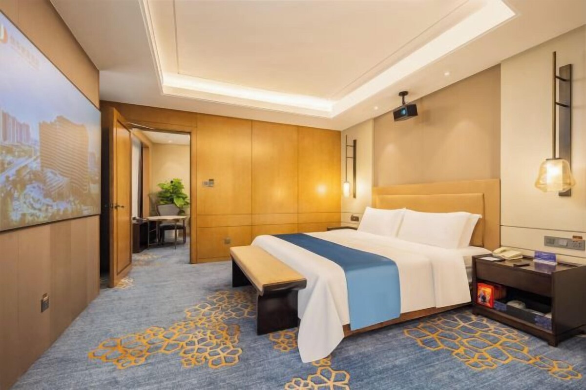 Una habitación de hotel con una cama grande, un escritorio y vistas a la ciudad.