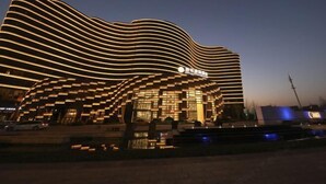 A modern building with a unique wavy facade and illuminated lines. - Shangqiu Xinhua Jianguo Hotel (Shangqiu)