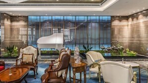 A luxurious lobby with elegant furniture, a grand piano, and a large window offering a city view. - Shangqiu Xinhua Jianguo Hotel (Shangqiu)