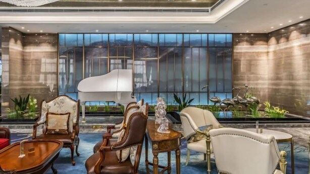 A luxurious lobby with elegant furniture, a grand piano, and a large window offering a city view. - Shangqiu Xinhua Jianguo Hotel (Shangqiu)