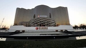 A modern building with a unique wavy roof design and a central dome structure. - Shangqiu Xinhua Jianguo Hotel (Shangqiu)