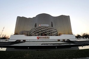 Un edificio moderno con un diseño de techo ondulado y una estructura cúpula central.