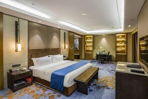A hotel room with a large bed, bedside tables, a desk, and a TV. - Shangqiu Xinhua Jianguo Hotel (Shangqiu)