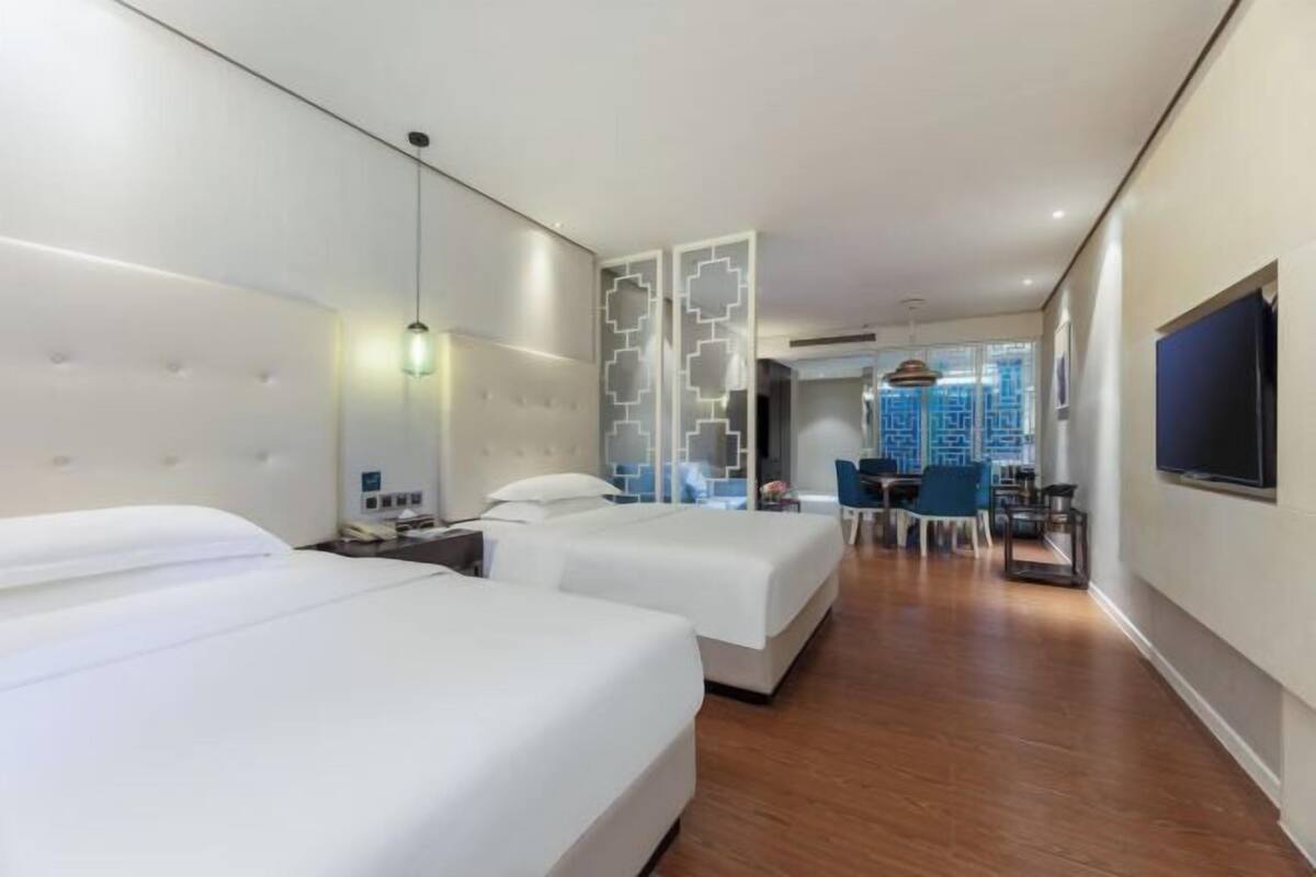 Una habitación de hotel con dos camas, un escritorio y una televisión.