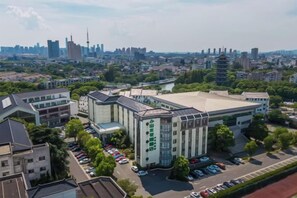 Un grand bâtiment à étages, entouré d’aires de stationnement et d’espaces verts.