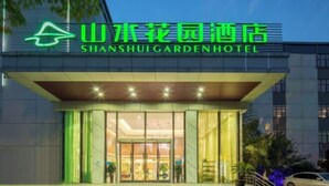 Exterior del Hotel Shanshui Garden con diseño moderno, destacando un llamativo letrero de neón y una entrada bien iluminada.