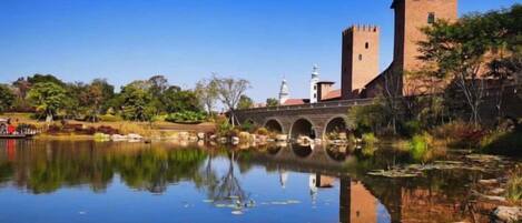 A historic building with a tower and arched bridge over a calm body of water.