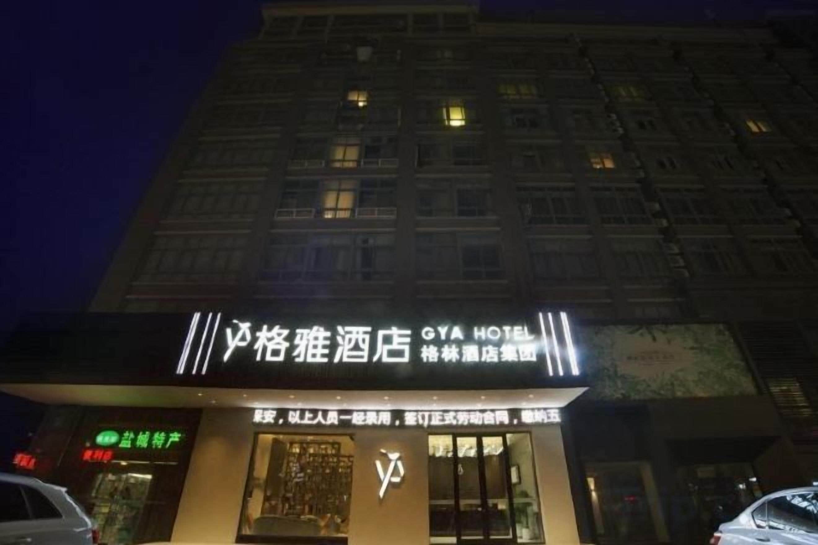 A hotel with a prominent sign, a visible entrance, and a building facade with windows.