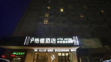 A hotel with a prominent sign, a visible entrance, and a building facade with windows.