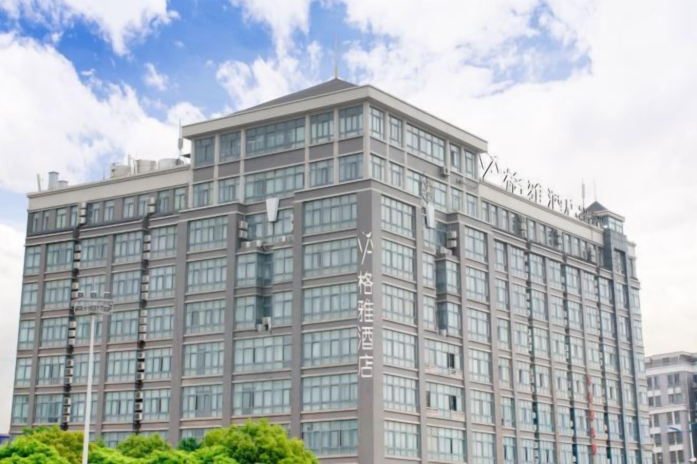 A multi-story hotel with a modern architectural design, featuring a prominent entrance and a large glass facade.