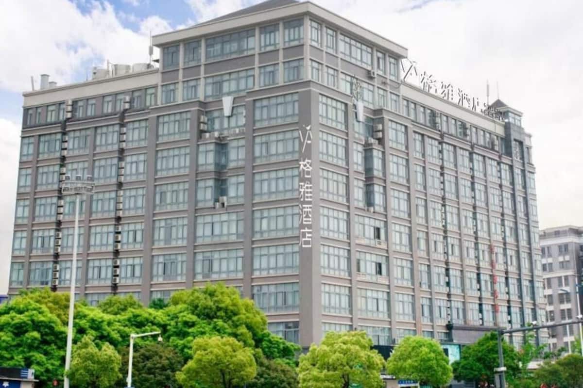 A multi-story hotel with a modern design, featuring a prominent vertical sign on the facade.