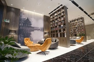 Un vestíbulo moderno con asientos, estanterías y un gran mural en la pared.