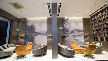 A lobby with seating areas, a bookshelf, and a large mural.