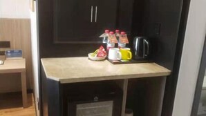 A compact kitchenette with a small refrigerator, a coffee maker, and a microwave. - GYA Hotel (Yancheng Wengang Road High-speed Railway Station) (Yancheng)