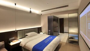Ein Hotelzimmer mit Bett, Nachttisch und einem großen Spiegel.