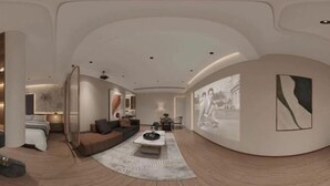 Ein modernes Interieur mit gewölbter Decke, einer Couch, einem Couchtisch und Wandbildern.