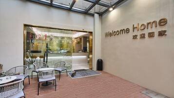 A reception area with a 'Welcome Home' sign, a reception desk, and a seating area with chairs and a table.