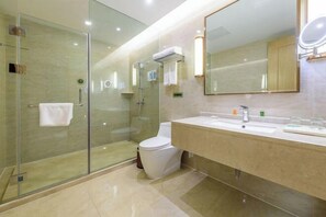 A modern bathroom with a glass-enclosed shower, a toilet, and a vanity with a mirror.