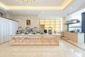 A modern kitchen with a central island, equipped with various appliances and utensils. - Vienna International Hotel (Wuxuan Chengbei Road) (Wuxuan)