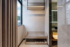 Une salle de bain moderne dotée d’un meuble à chaussures intégré et d’une grande fenêtre.