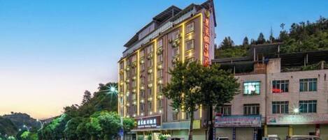 A multi-story hotel with a modern design, featuring a prominent entrance and multiple windows.