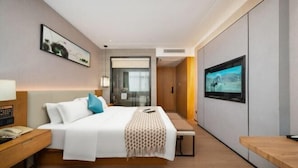 A modern hotel room with a bed, bedside table, bench, TV, and artwork on the walls. - Super Comfy (Shenzhen)