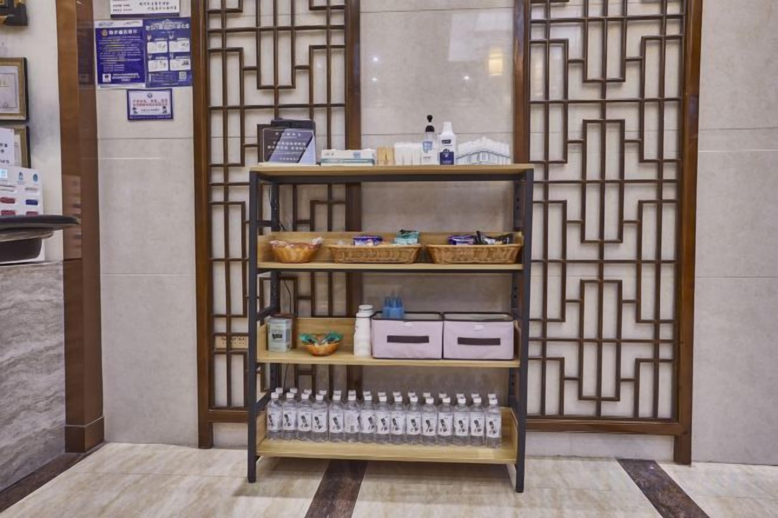 A reception area with a reception desk, a decorative screen, and a shelf with baskets and bottles.