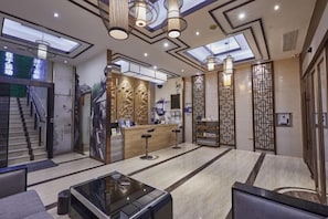 A hotel lobby with a reception desk, seating area, and a staircase. - Xueyuan Chain Hotel (Wenzhou College City) (Wenzhou)