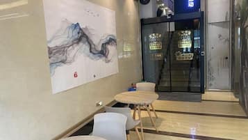 A modern interior with a large abstract painting, a reception desk, and a sign for a fitness center.