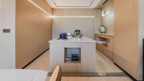 A modern hotel room with a central island, wooden paneling, and a minimalist design. - Kester Business Hotel (Qianxi)