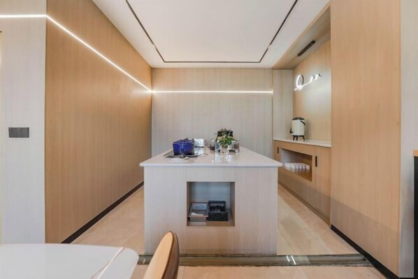 A modern hotel room with a central island, wooden paneling, and a minimalist design. - Kester Business Hotel (Qianxi)