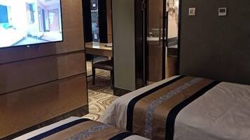 Una habitación de hotel con una cama, un escritorio y un televisor en la pared.