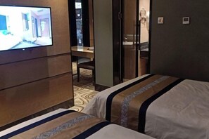 A hotel room with a bed, a desk, and a television mounted on the wall. - Xiya Inn (Lanzhou)