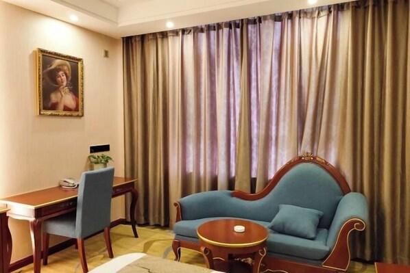 A room with a desk, chair, sofa, and curtains. - Yixin Hotel (Emin)