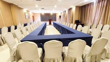 Una sala de conferencias con una mesa larga, sillas y un atril.
