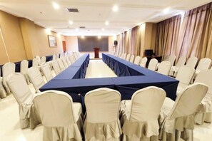 A conference room with a long table, chairs, and a podium. - Yixin Hotel (Emin)