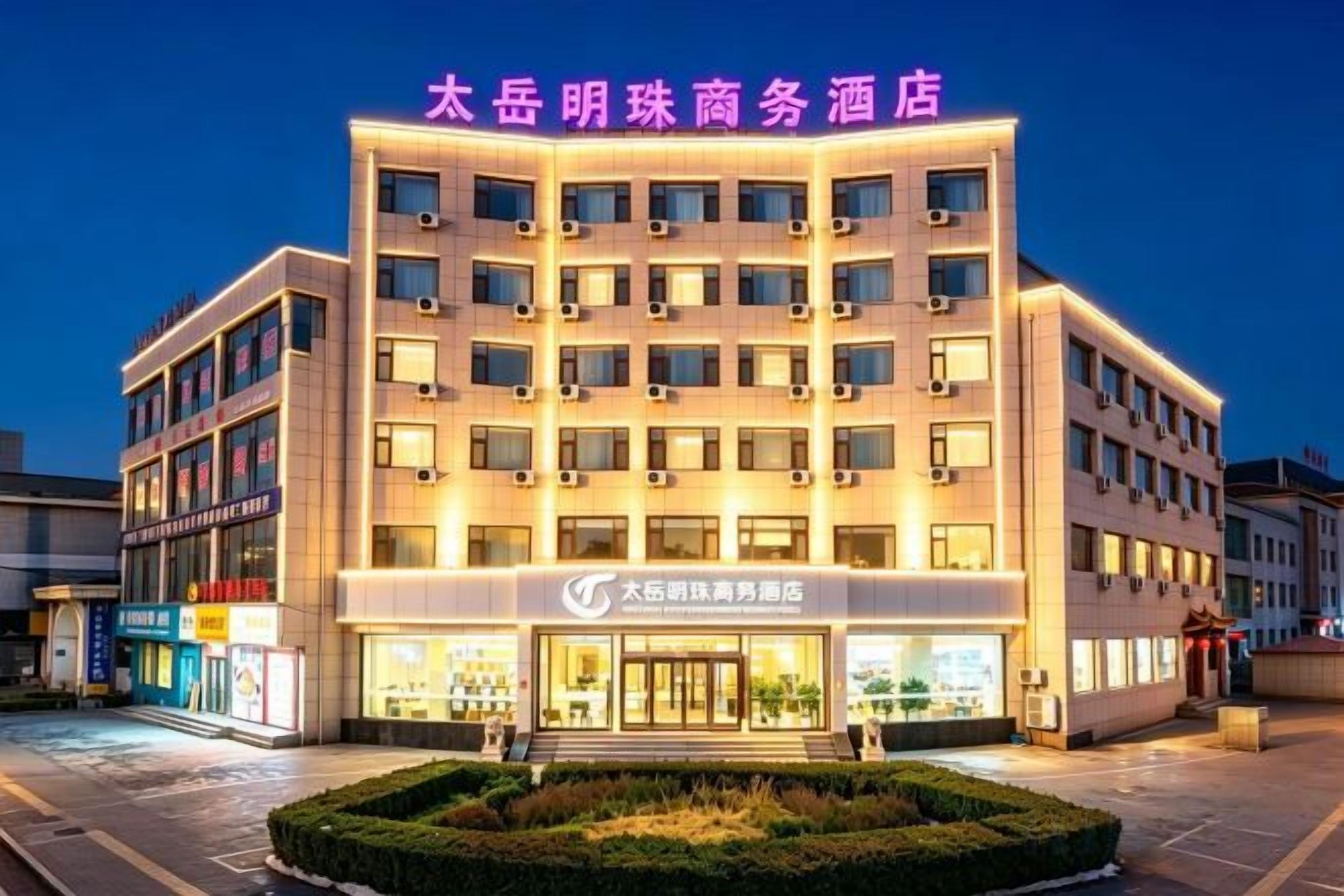 A hotel with multiple floors, a well-lit entrance, and a sign indicating it is a business hotel.