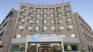 A multi-story hotel building with a sign indicating it is the Taiyuan Pei Xiang Hotel.