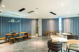 Une chambre d’hôtel avec un coin repas, une plante et une grande fenêtre.