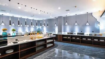 A modern kitchen with pendant lighting, marble countertops, and a central island.