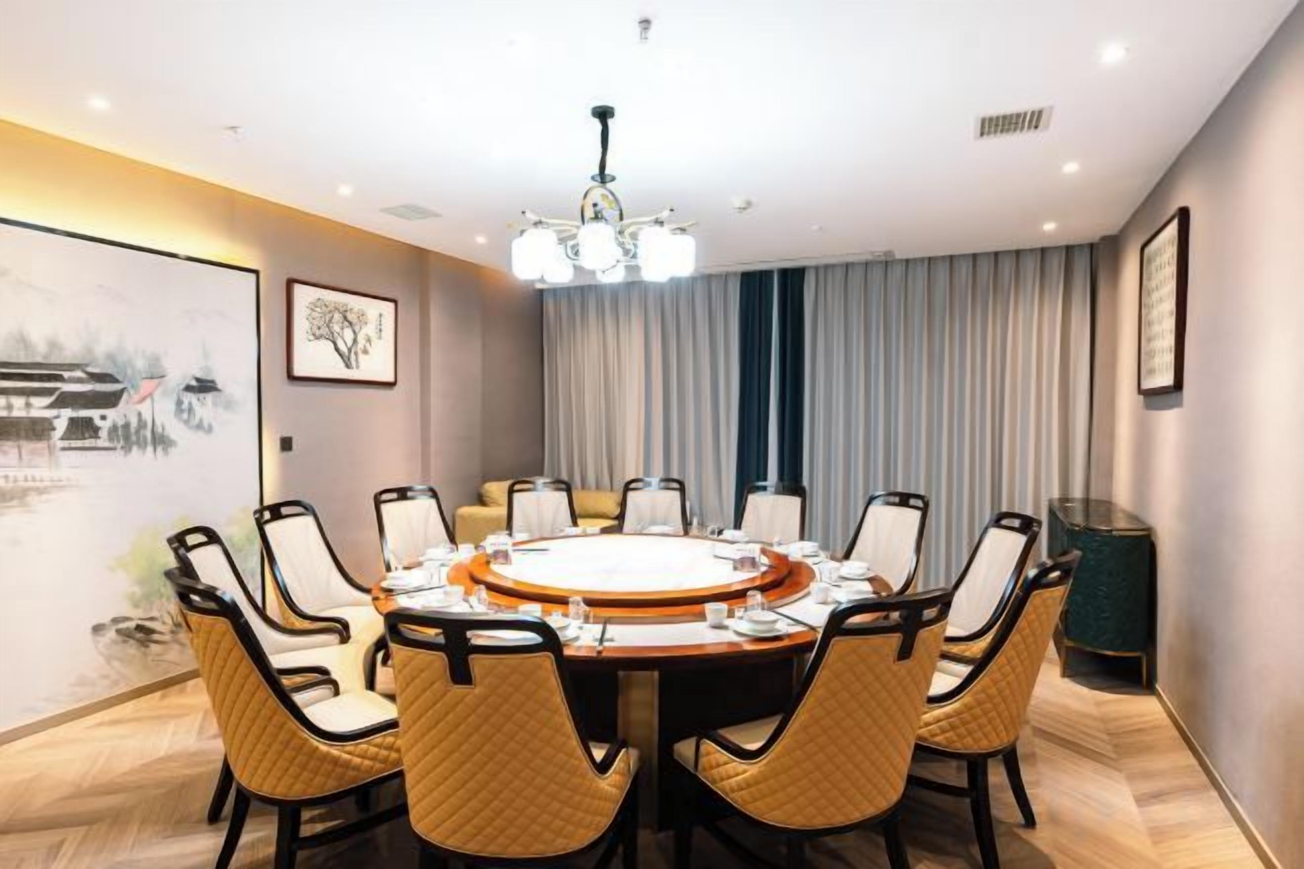 A conference room with a round table, chairs, and a chandelier.