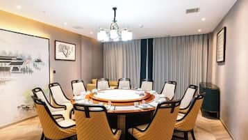 A conference room with a round table, chairs, and a chandelier.