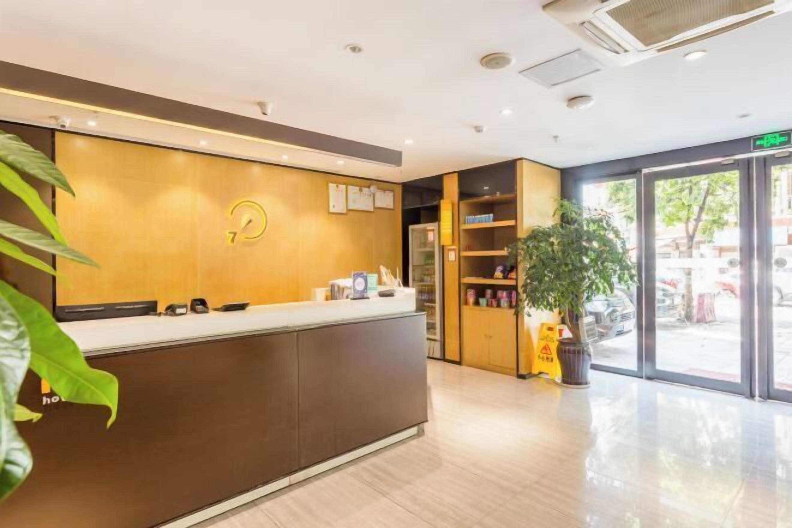 A reception area with a wooden reception desk, a clock, and a plant.
