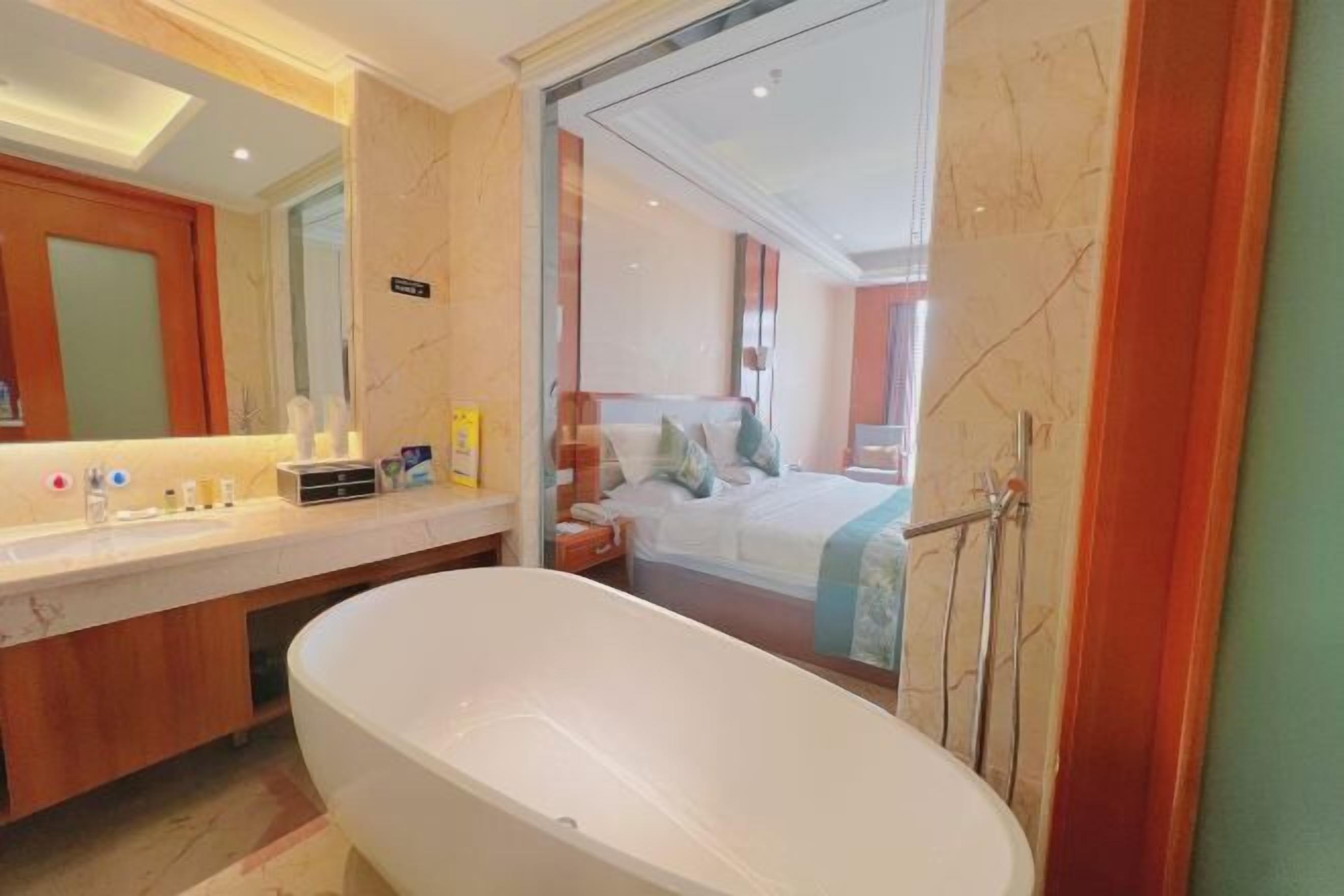 A modern bathroom with a large bathtub, a vanity with a mirror, and a shower area.